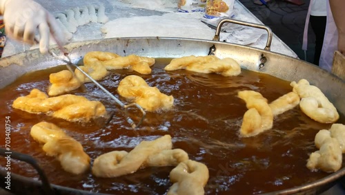 You tiao or Chinese Doughnut. Making Chinese deep-fried fluffy dough sticks. photo