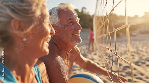 Active senior couple on a volleyball court at the beach photo