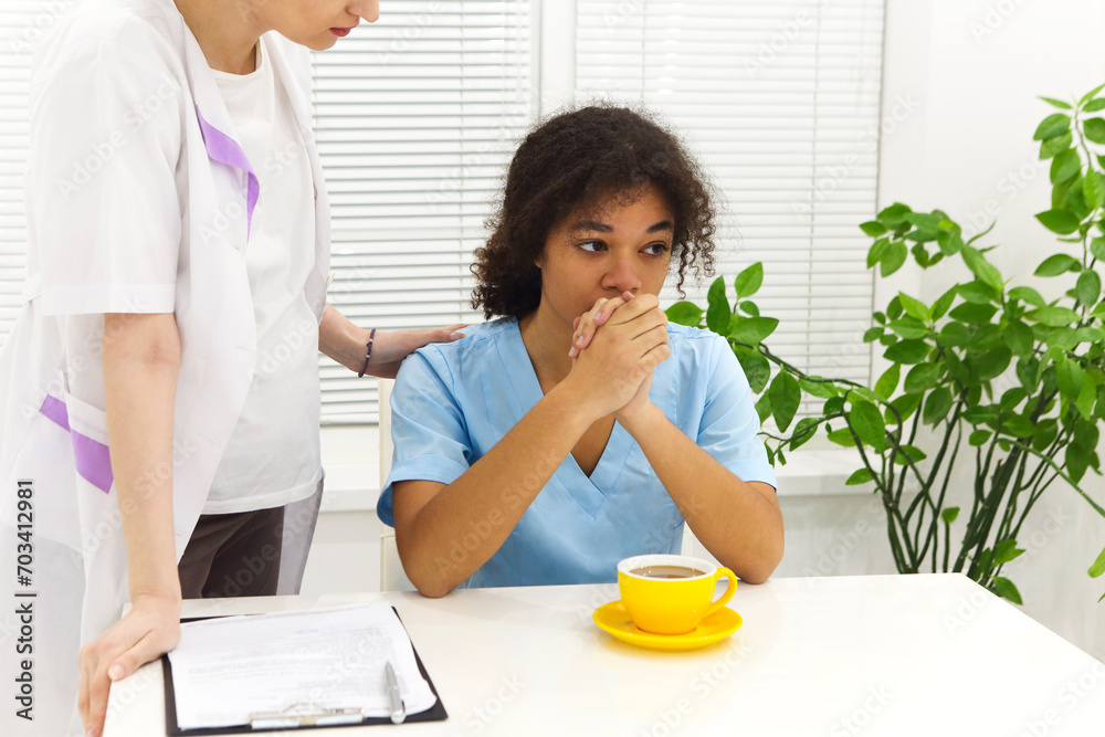 Crying upset mixed race nurse or afro american doctor with problems having stress breakdown at work Crying upset mixed race nurse or afro american doctor with problems having stress breakdown at work