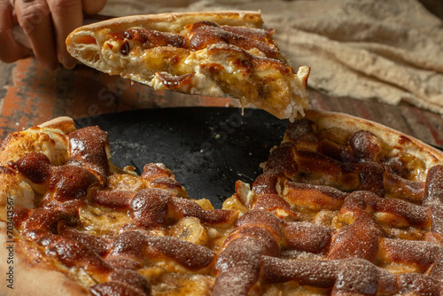 slice of sweet Pizza with banana, sweet meringues and cinnamon. Traditional Brazilian sweet pizza with banana and meringues.