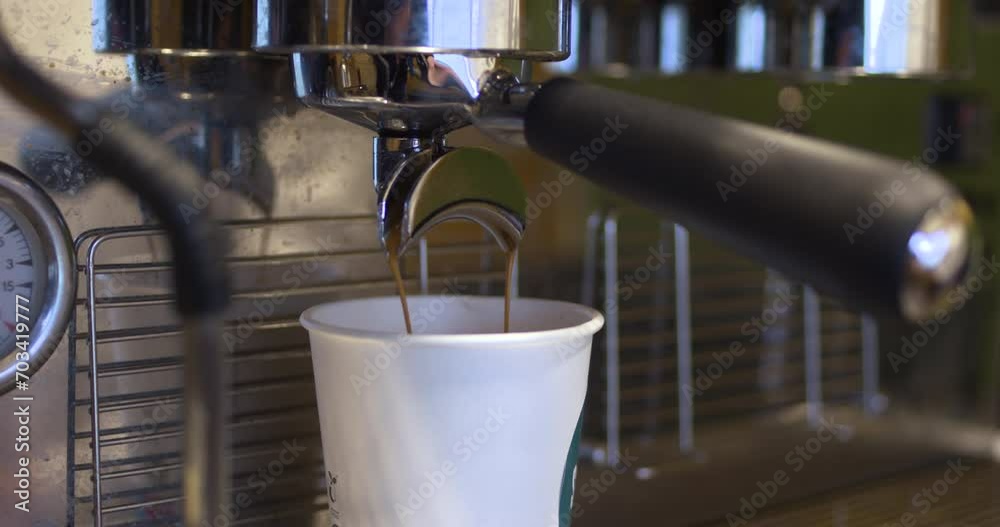 Coffee drips slowly into disposable take out cup Coffee drips slowly into disposable take out cup