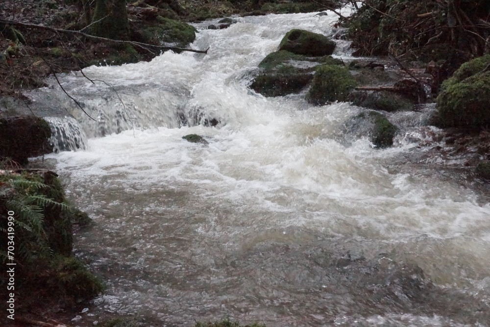 Ein Bach nach ergiebigen Regen mit Felsen und Steinen und ein Bach ohne Wasser nur Steine Ein Bach nach ergiebigen Regen mit Felsen und Steinen und ein Bach ohne Wasser nur Steine