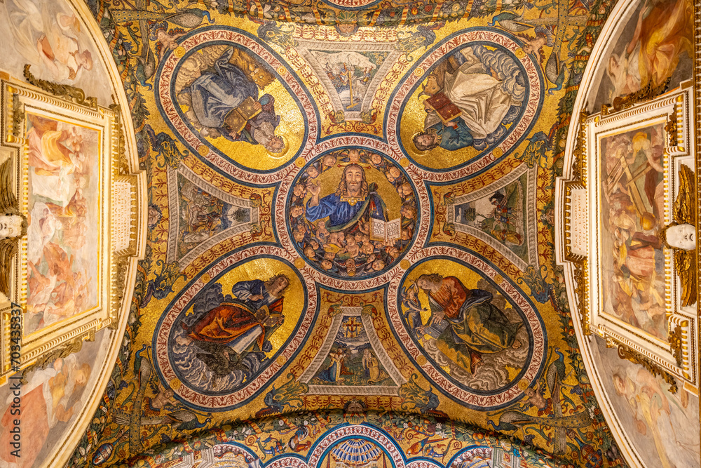 Close-up on colorful religious mosaic decorating interior of historic Basilica in Rome showing four saints surrounding Jesus Christ