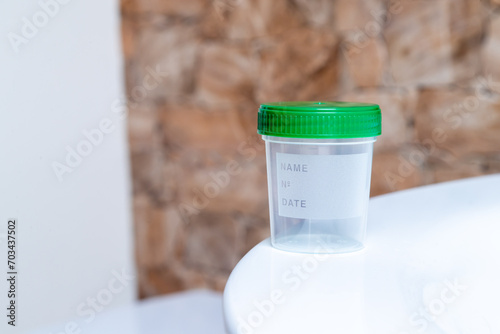 Leerer Urinbecher zum abgeben einer Urinprobe zu Hause im Bad photo