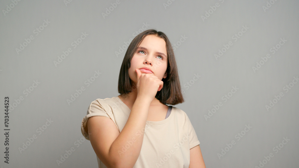 Amazing short hairdo latin teenager looking up empty space deep thinking creative person and coming with idea isolated over gray background Amazing short hairdo latin teenager looking up empty space deep thinking creative person and coming with idea isolated over gray background