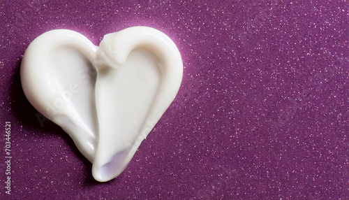 White beauty skincare cream swipe smear in heart shape on glitter purple surface