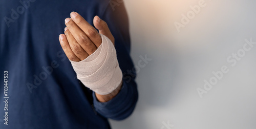 close up adult man hand with bandage support after get injured by accident for insurance claim and health lifestyle concept photo