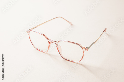 Stylish plastic eyeglasses isolated on light beige background perspective view