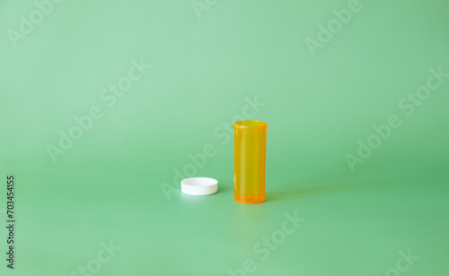 Empty prescription medication bottle on the green background. Medication concept