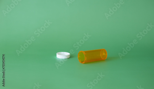 Empty prescription medication bottle on the green background. Medication concept