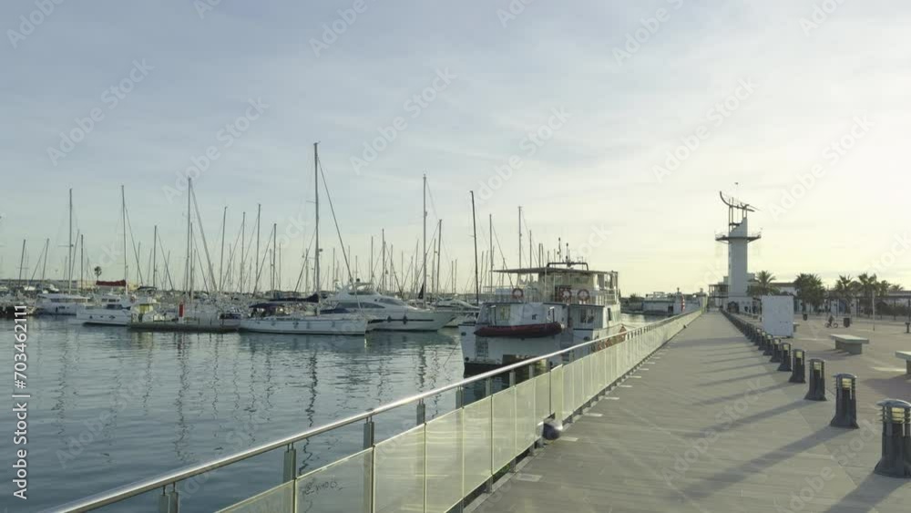 Yachts at the dock in the port Grao of Castellon of winter. The masts of the yachts sway against the blue sky. Spain Yachts at the dock in the port Grao of Castellon of winter. The masts of the yachts sway against the blue sky. Spain