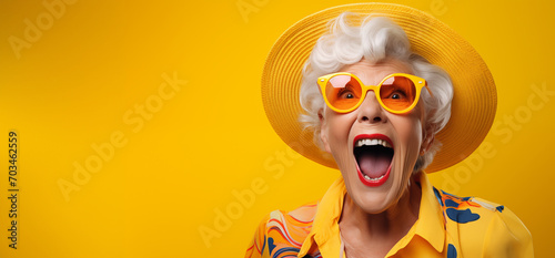 Le cri d'une vieille femme portant des lunettes et un chapeau, arrière-plan orange, image avec espace pour texte.