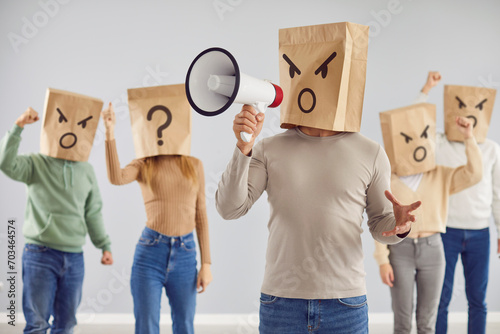 Angry frustrated disappointed mad emotional anonymous adult crowd protests with shopping bag disguise on heads, screams in megaphone loud speakers, demands justice for customer scam discrimination