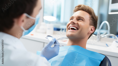 Patient with a bright smile sitting in a dental chair  looking up at a dentist who is examining him