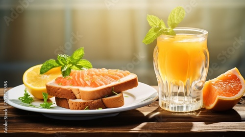 Breakfast set with bread top with salmon and serve with orange juice set up on the table