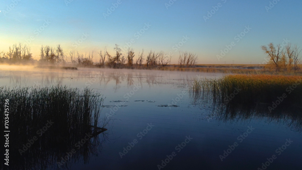 Colorful fog over the lake in autumn at dawn
