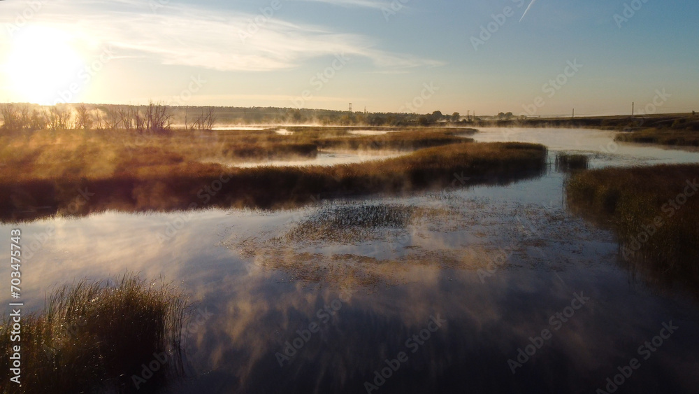 Colorful fog over the lake in autumn at dawn