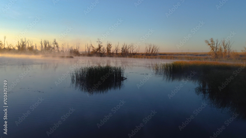 Colorful fog over the lake in autumn at dawn