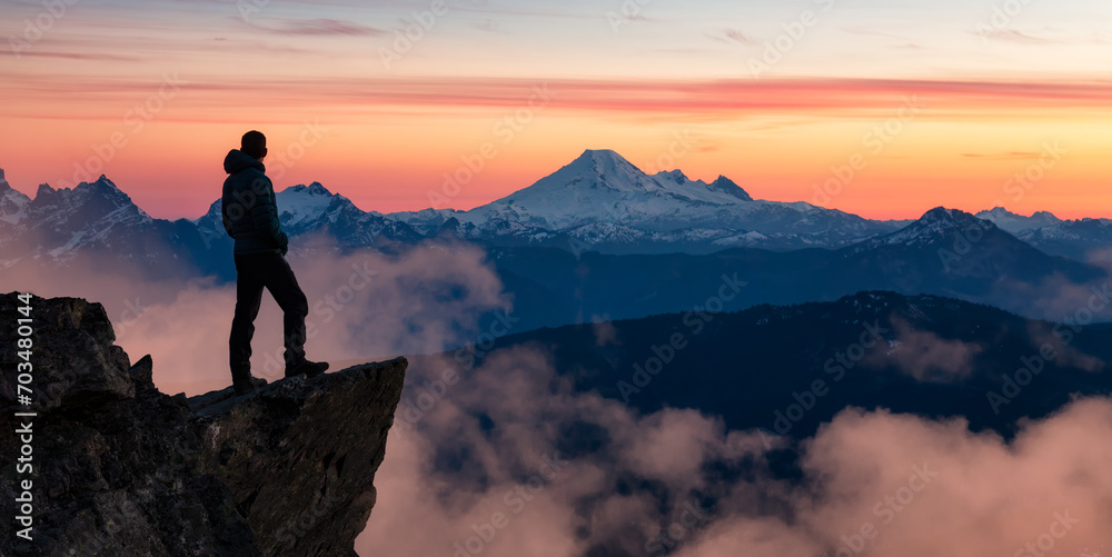 Adventure Hiker on Mountain Peak with Canadian Mountain Landscape in Background.