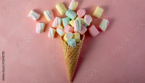 marshmallow candy colorful assortment in an ice cream cone on a pink background viewed from above gummy candy variation top view
