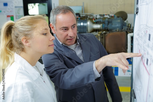 engineer showing intern a blueprint