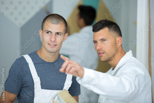 two painters pointing at something
