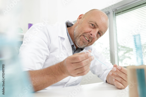 mature male laboratorian working with pipette in lab