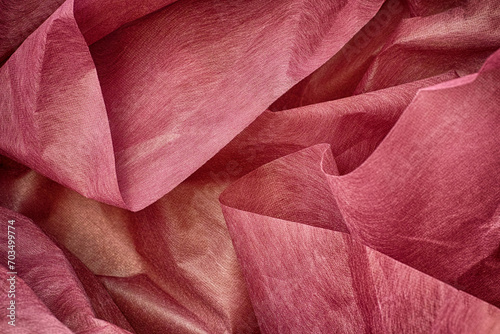 A background of crumpled pink wrapping paper. Close up.