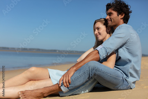 pretty girl cuddling with boyfriend on beach