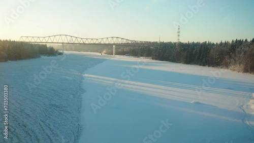 The Svir is a large river in the northeast of the Leningrad region of Russia. View of the river and railway bridge from the train window. Frosty winter day photo