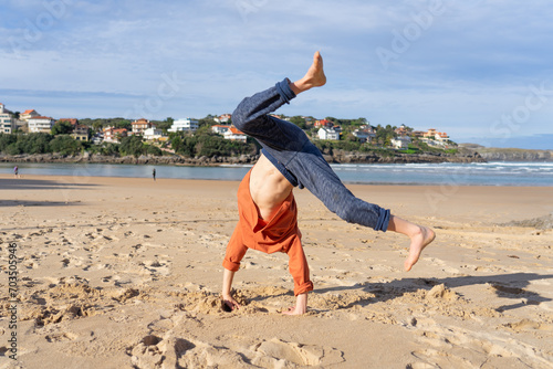 Boy doing cartwheel on the beach photo