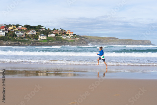 Boy running along the seashore