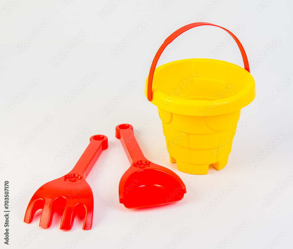 Children's toy bucket with shovels for playing in the sand on a white background. Children's toy bucket with shovels for playing in the sand on a white background.