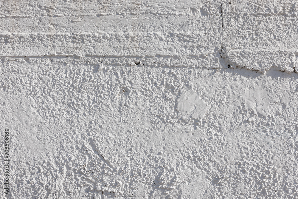 rough whitewash or white plaster wall under direct sunlight, full-frame background and texture. rough whitewash or white plaster wall under direct sunlight, full-frame background and texture.