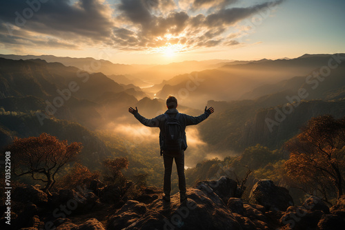 Man silhouette standing on rocky cliff peak enjoying view with arms open. Generative AI.
