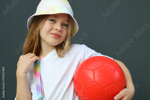 Soccer player girl celebrating success with ball, active youth competition and enjoyment.