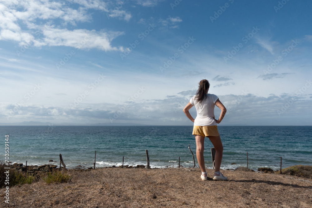 Authentic woman enjoying a calming moment on the beach. With copyspace.