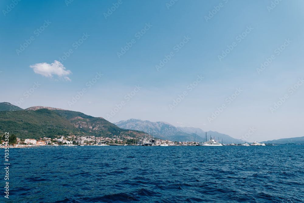 Yachts sail in the sea against the background of a mountainous resort coast