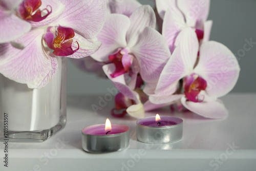 Pink phalaenopsis orchid flower  candle on beige. Selective soft focus. Minimalist art still life. Light and shadow background.
