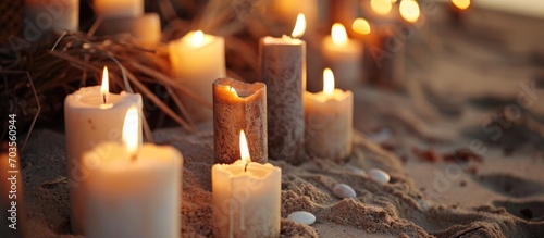 Mix of white and brown candles placed on sand.