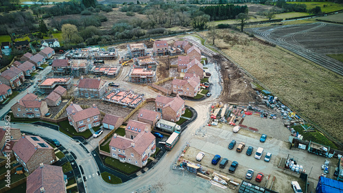 Aerial view of a residential development with houses and construction site, showcasing suburban expansion.