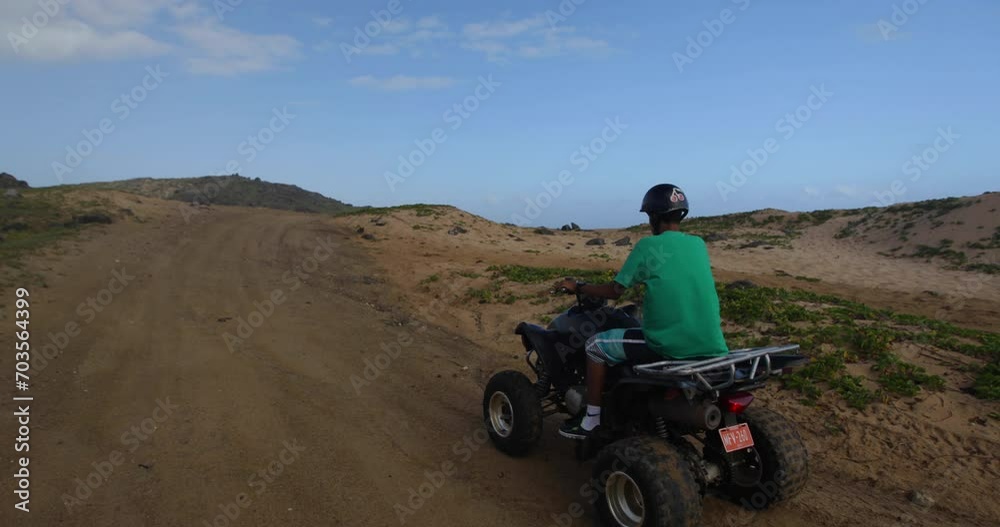 Four wheelers on dirt road passes by others - Wide, following shot Four wheelers on dirt road passes by others - Wide, following shot
