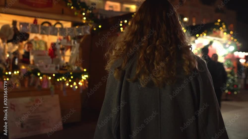 following shot Young blonde woman walking through a festive Christmas market passing by people following shot Young blonde woman walking through a festive Christmas market passing by people