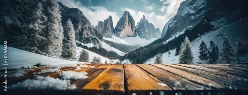 Snow-covered mountain peaks of the Dolomites rise majestically in Italy. Winter nature landscape in Alps. Wooden desk background. Panorama with copy space.