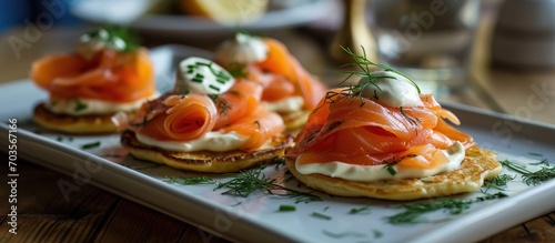 Smoked salmon and dill garnished blini with sour cream.