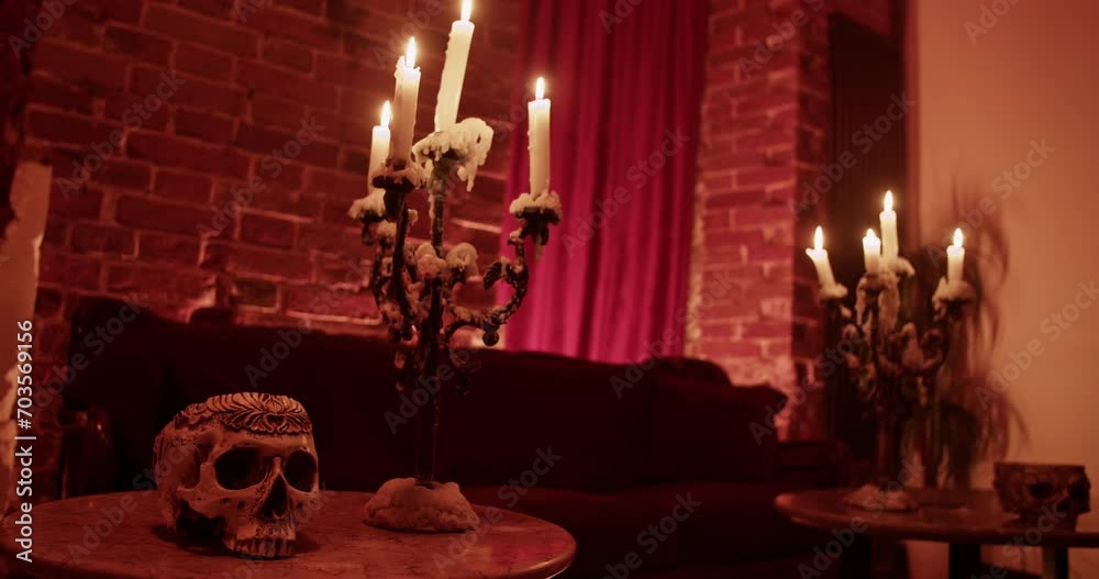 Burning candles with spooky skull on table at home Burning candles with spooky skull on table at home