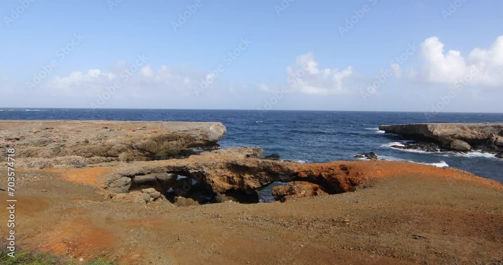View of ocean shore and rocky arch - Wide, steady cam shot View of ocean shore and rocky arch - Wide, steady cam shot