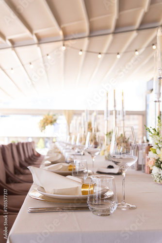 Serving the festive table at a wedding event. Decorating the wedding table with bouquets of flowers. Cutlery at a party 