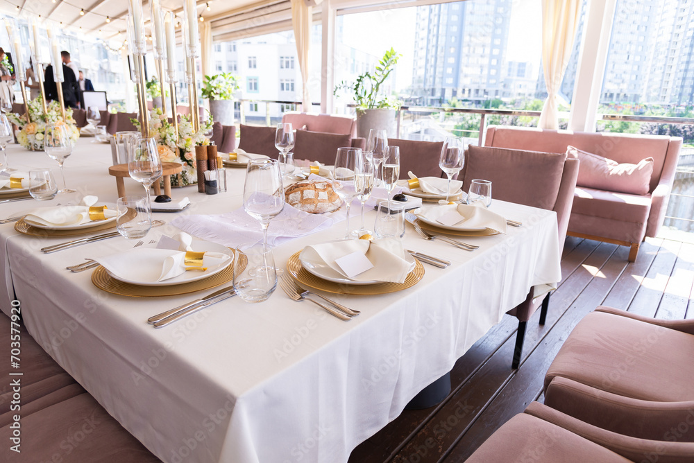 Serving the festive table at a wedding event. Decorating the wedding table with bouquets of flowers. Cutlery at a party Serving the festive table at a wedding event. Decorating the wedding table with bouquets of flowers. Cutlery at a party