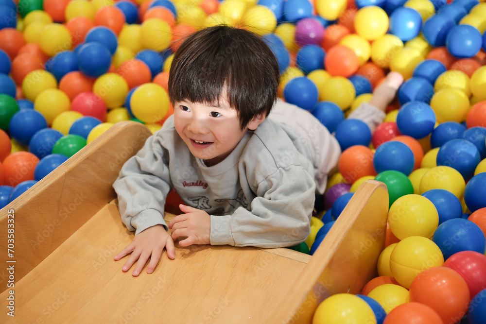 Fototapeta premium ボールプールで遊ぶ男の子